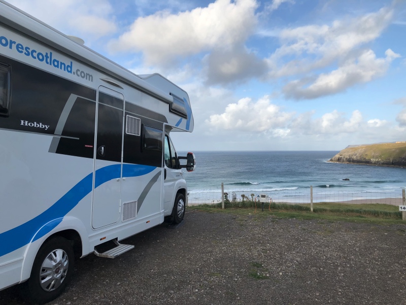 A bus parked on the side of a road next to a body of water